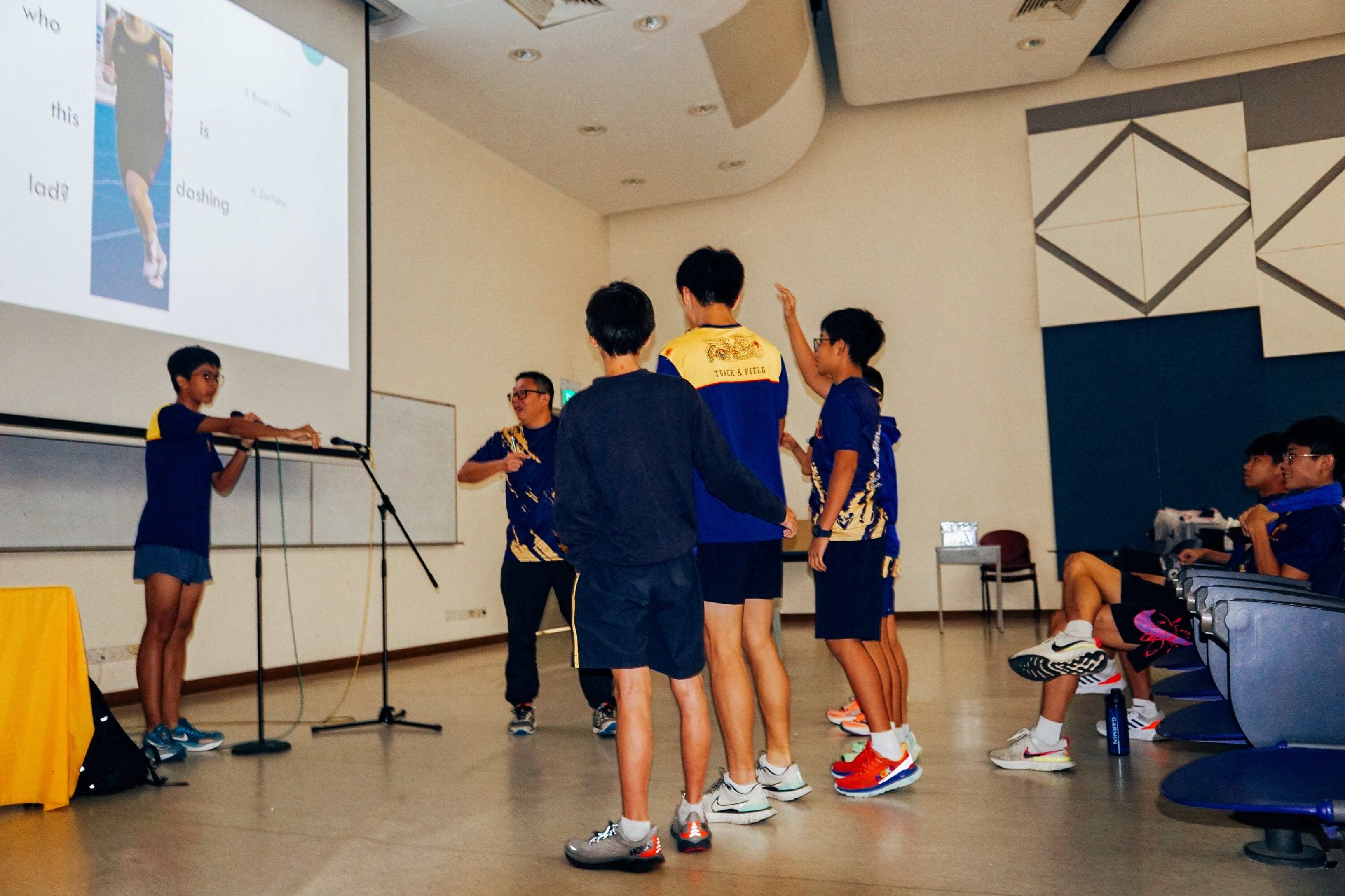 A group of students playing guess who in an indoor lecture hall